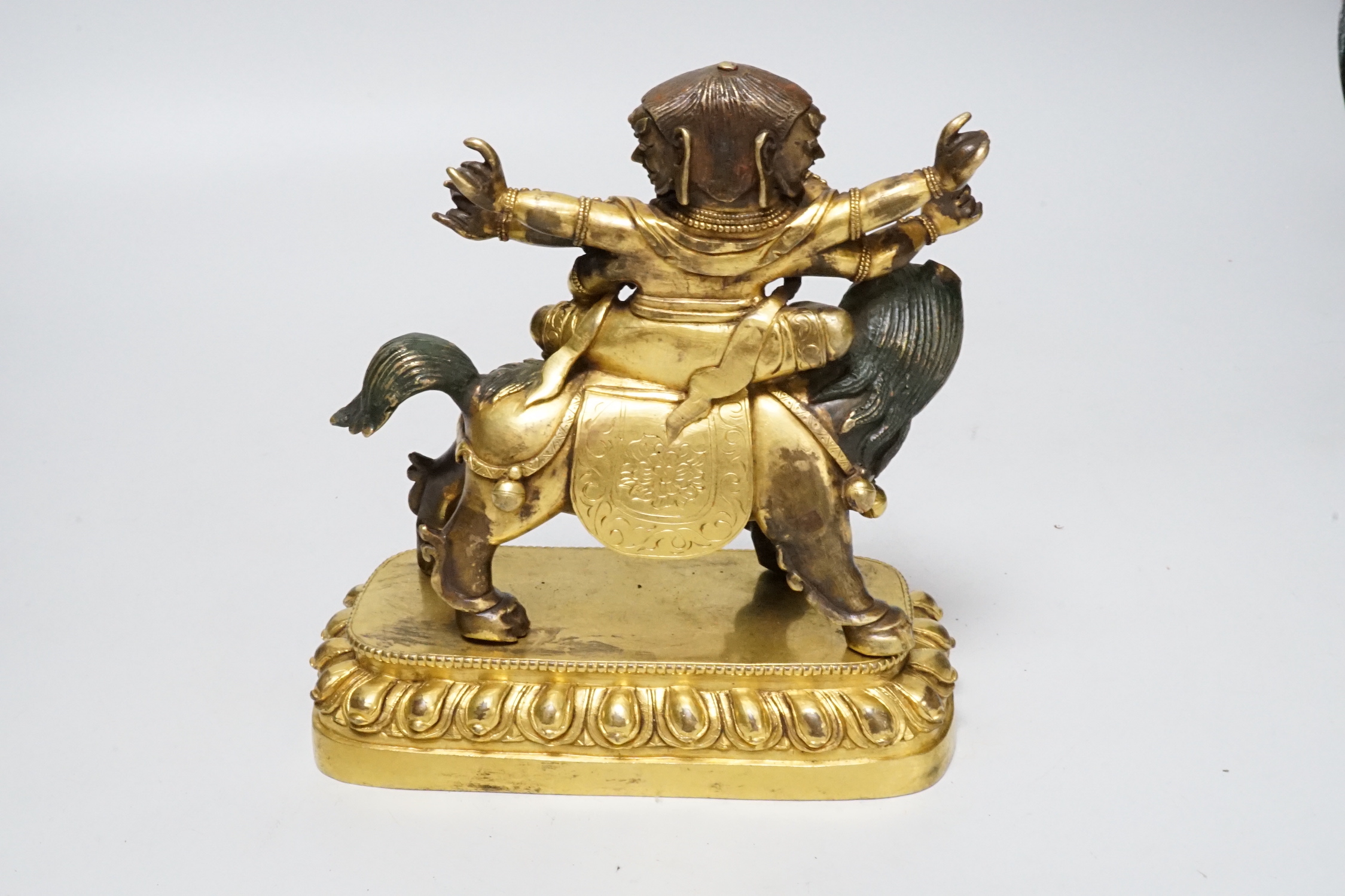 A Sino-Tibetan gilt bronze group of a deity on lionback, 15cm wide